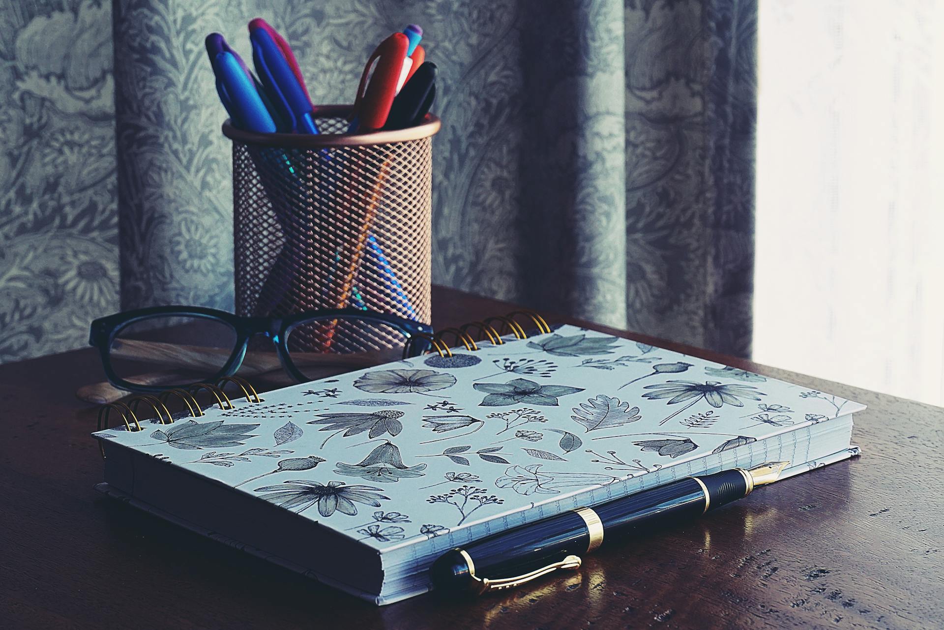A clean study desk with book, pen, glasses, and pen case used in a 7 day Smart study routine